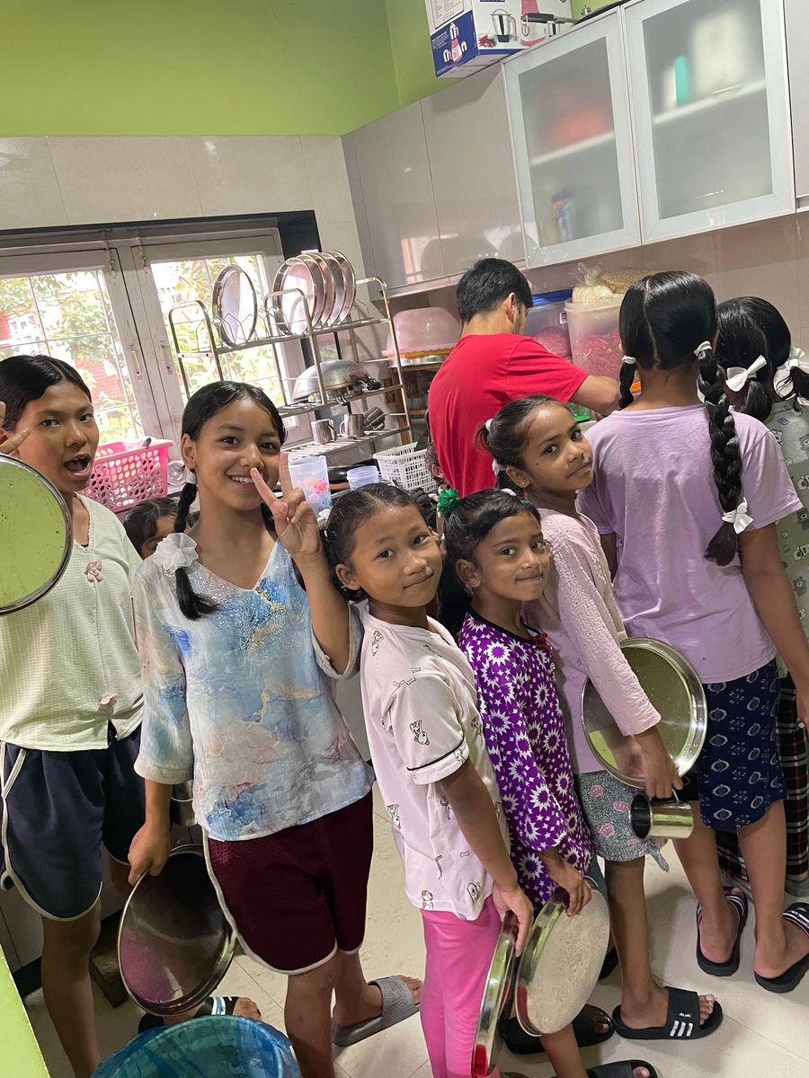 Children helping with the dishes in the hostel house kitchen