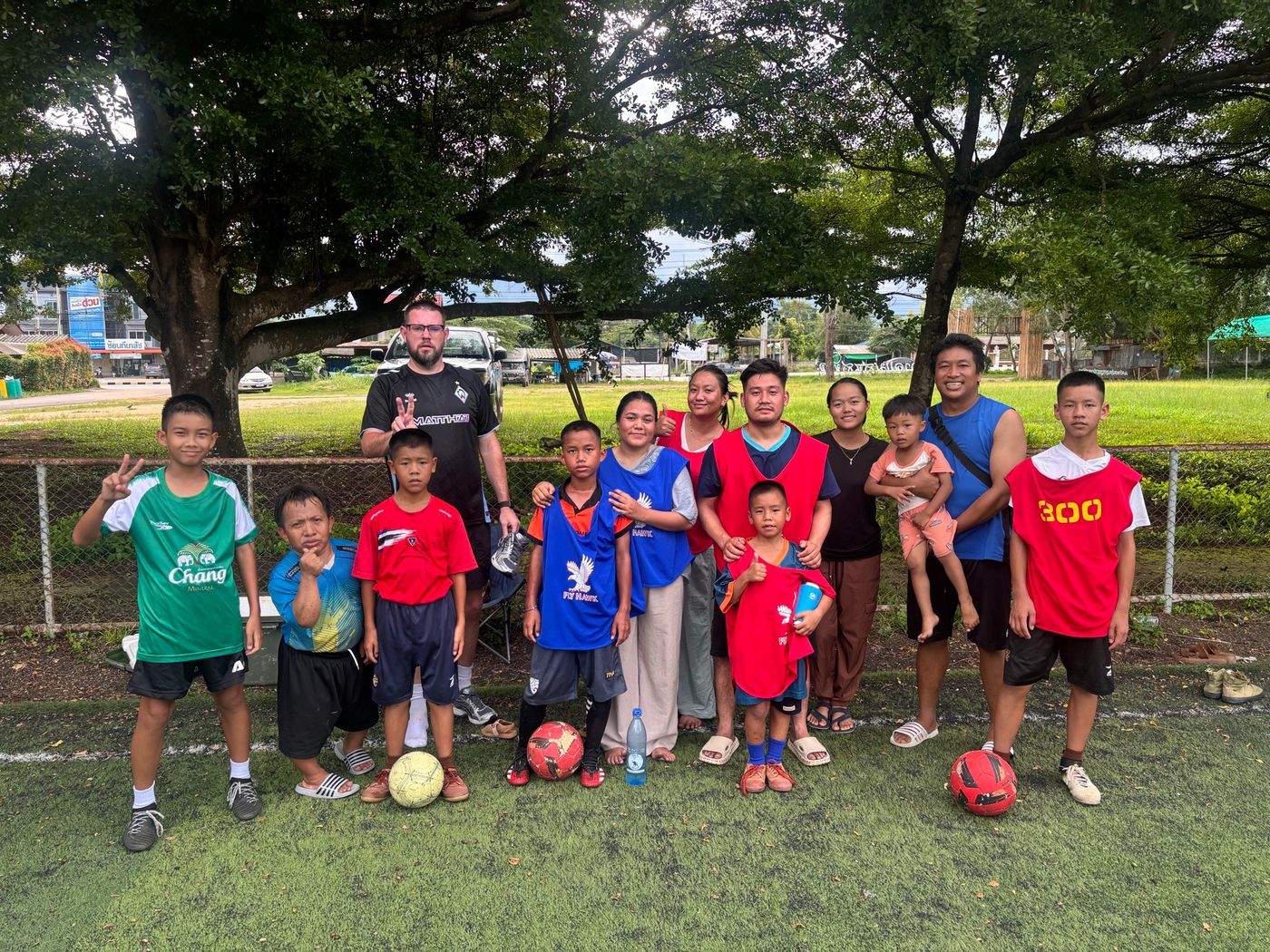 Children and coaches with footballs after a training session