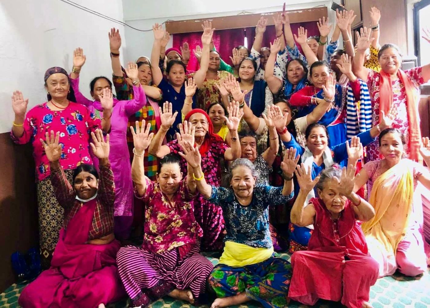 Women of the Women Ministry raising their hands together in worship