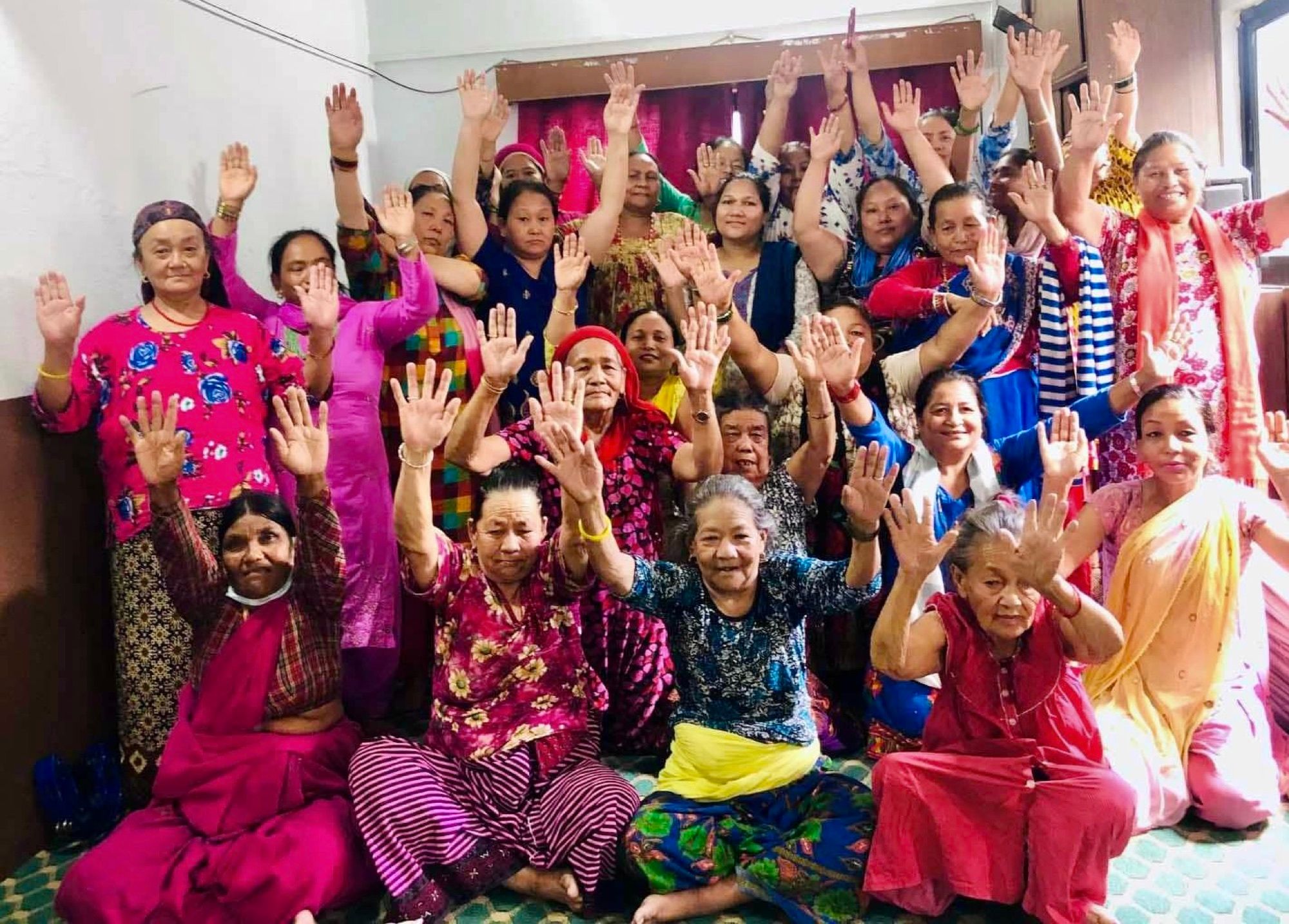 Women of the Women Ministry raising their hands together in worship